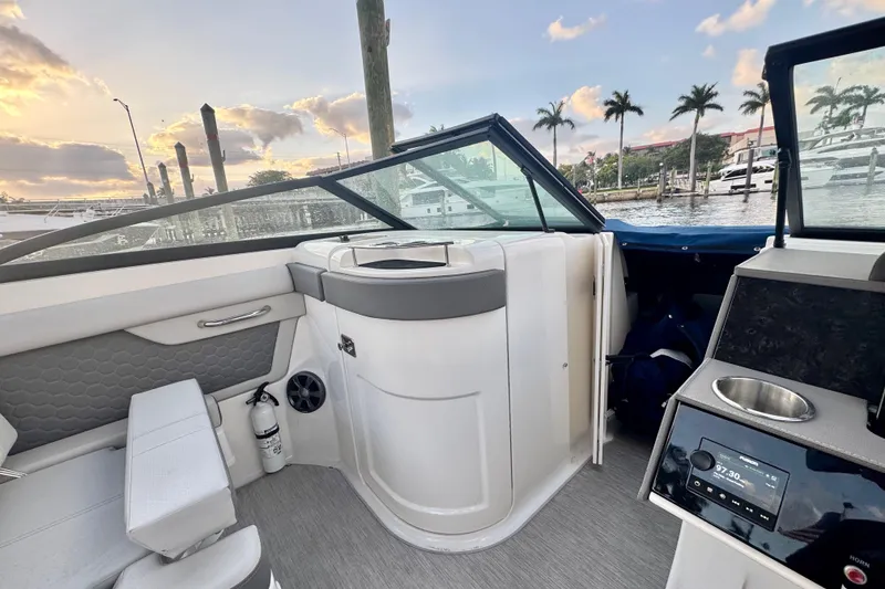 Slide: The Image of 2021 Sea Ray SDX 270 boat interior with seating, console, and waterfront view. - 20