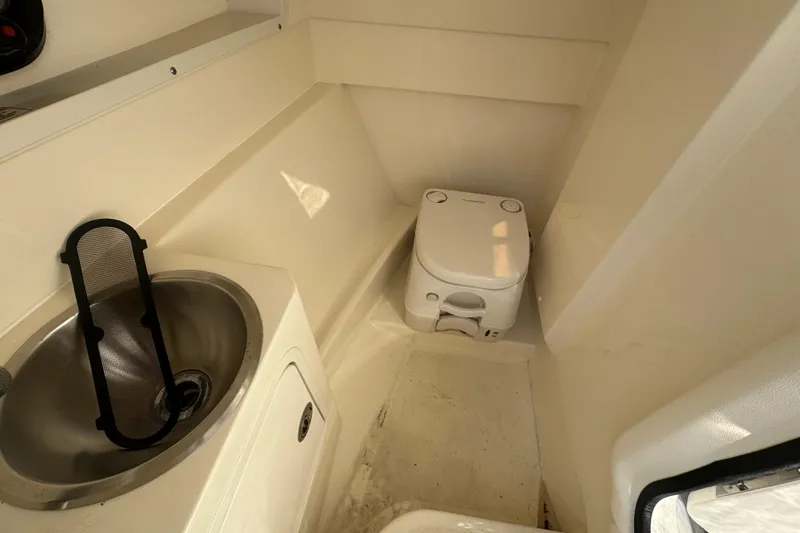 Slide: The Image of 2021 Sea Ray SDX 270 boat interior with compact toilet and sink. - 22