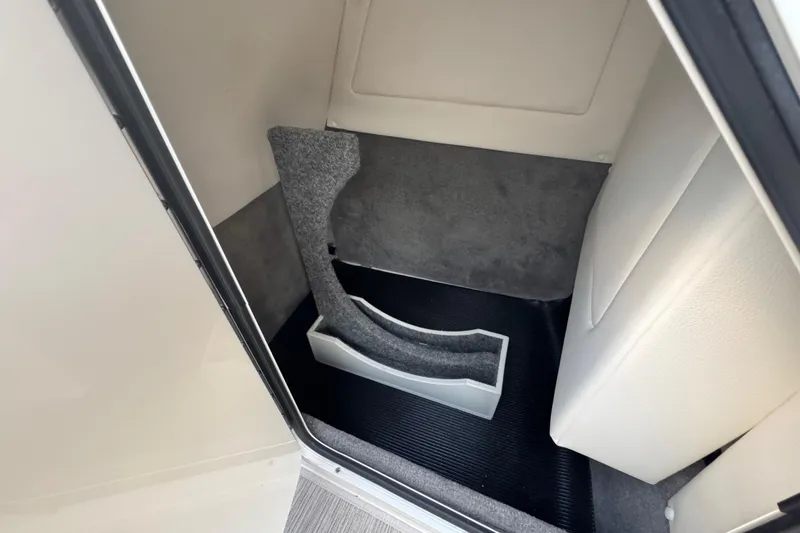 Slide: The Image of 2021 Sea Ray SDX 270 interior storage compartment with carpeted lining and sleek design. - 23
