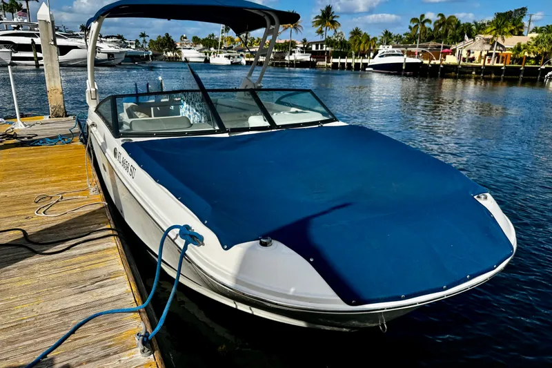 Slide: The Image of 2021 Sea Ray SDX 270 boat docked with blue cover, scenic waterfront view. - 26