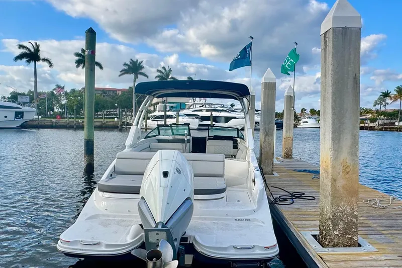 Slide: The Image of 2021 Sea Ray SDX 270 boat docked at marina with palm trees and blue sky. - 3