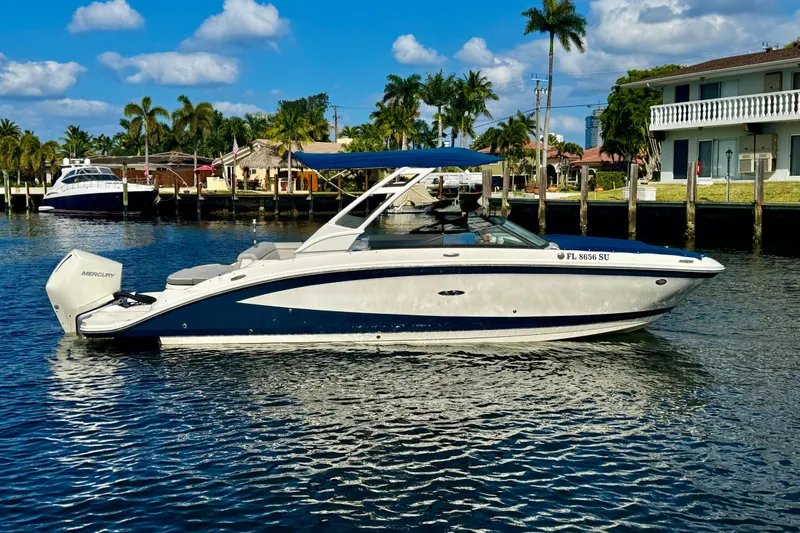 Slide: The Image of 2021 Sea Ray SDX 270 boat on a sunny waterfront with palm trees. - 31