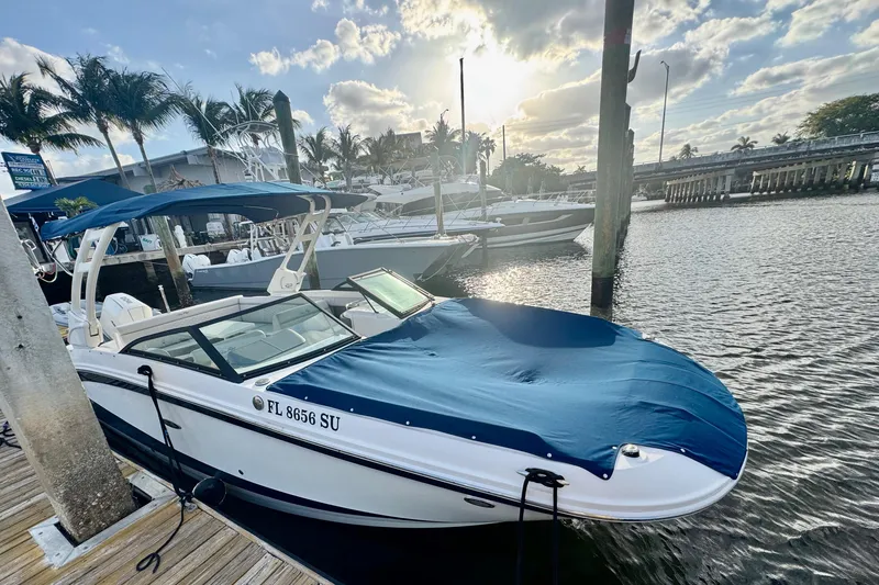 Slide: The Image of 2021 Sea Ray SDX 270 boat docked at marina, covered with blue tarp, sunny day. - 33