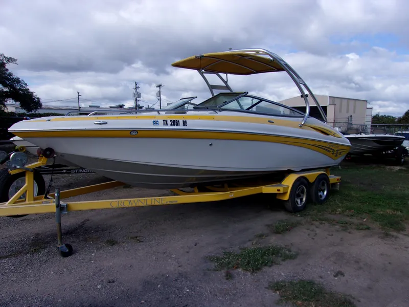 The Image of 2007 Crownline 23SS boat on trailer, yellow and white design, parked outdoors. - 1