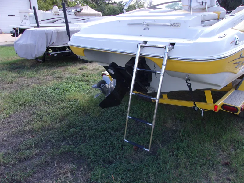 Slide: The Image of 2007 Crownline 23SS boat with ladder and propeller, parked on grass. - 3