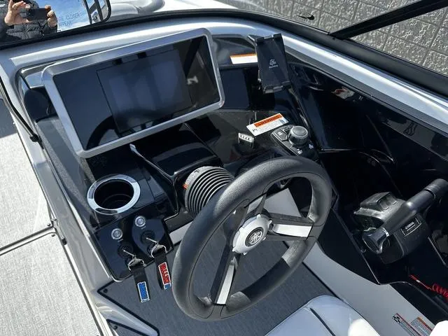 Slide: The Image of 2025 Yamaha AR250 boat dashboard with steering wheel, touchscreen, and controls. - 11