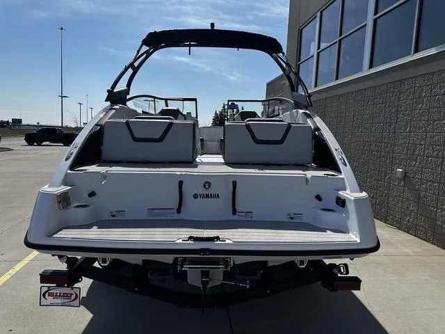 Slide: The Image of 2025 Yamaha Boats AR250, rear view, parked outdoors near a building. - 4