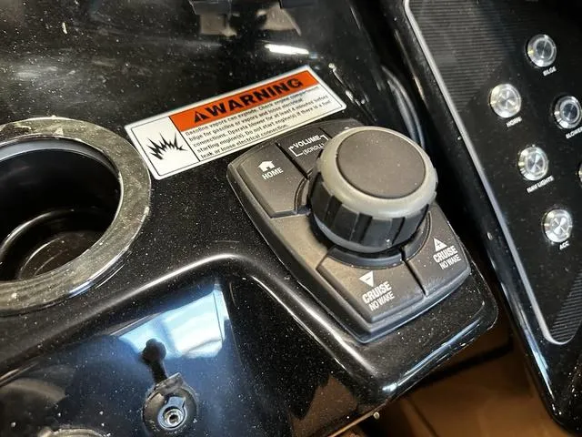Slide: The Image of Control panel of 2025 Yamaha Boats 255XD with warning label and navigation buttons. - 12