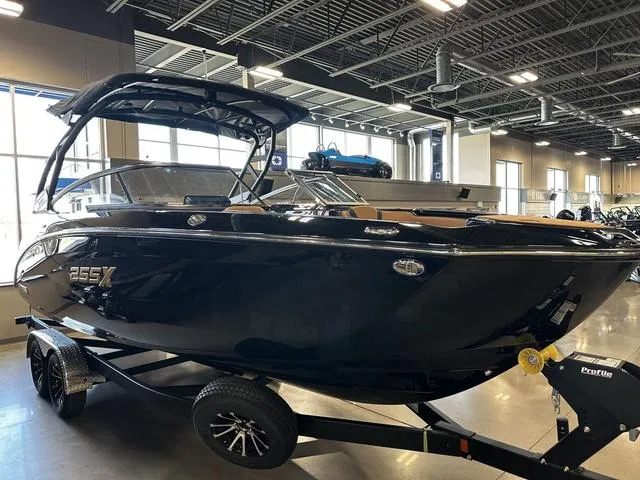 Slide: The Image of 2025 Yamaha Boats 255XD in showroom, sleek black design on trailer. - 4