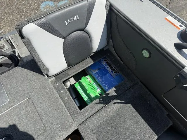 Slide: The Image of 2012 Lund 1750 Tyee boat interior with storage compartment and battery. - 14