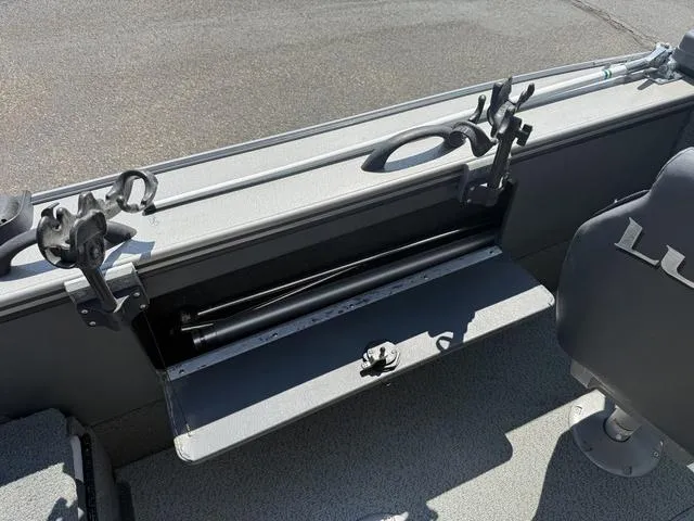 Slide: The Image of 2012 Lund 1750 Tyee boat interior with rod holders and storage compartment. - 16