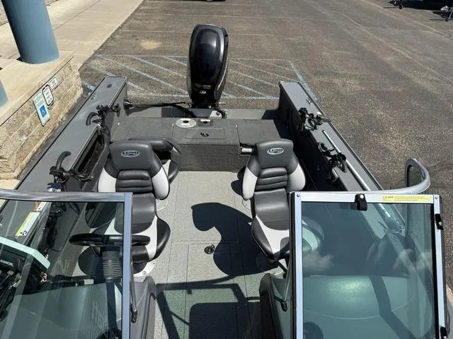 Slide: The Image of 2012 Lund 1750 Tyee boat with dual seats and outboard motor in parking area. - 24