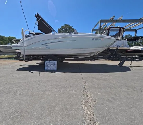 Slide: The Image of 2019 Chaparral 191 Suncoast boat on trailer, parked outdoors under clear blue sky. - 1