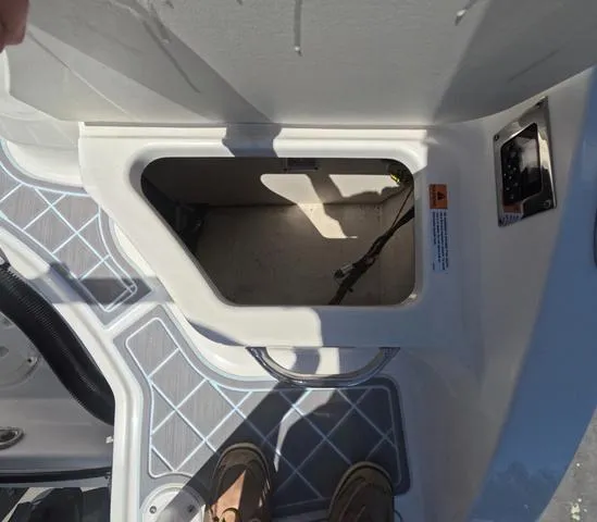 Slide: The Image of 2019 Chaparral 191 Suncoast boat storage compartment with open hatch and visible wiring. - 12