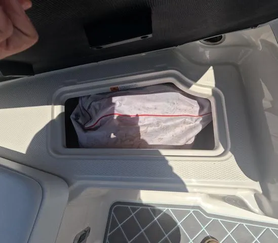 Slide: The Image of Storage compartment in 2019 Chaparral 191 Suncoast boat, partially open with a bag inside. - 35