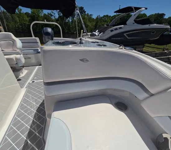 Slide: The Image of 2019 Chaparral 191 Suncoast boat interior with seating and control panel, docked outdoors. - 39