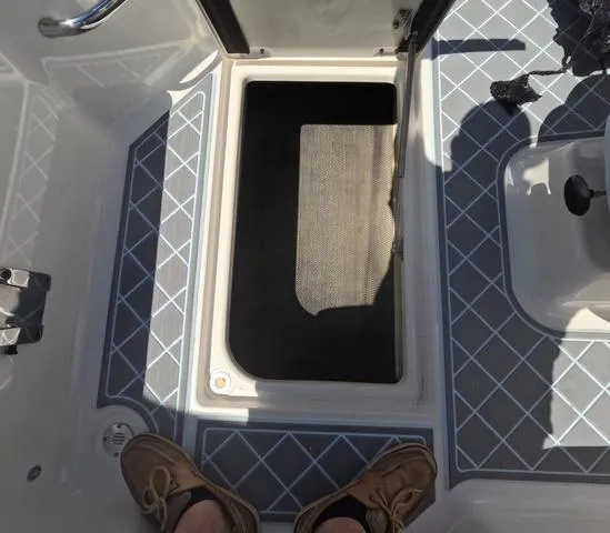 Slide: The Image of 2019 Chaparral 191 Suncoast boat storage compartment with open hatch and patterned flooring. - 44