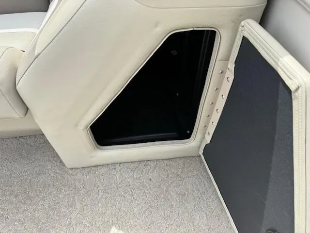 Slide: The Image of Interior storage compartment of a 2012 Lowe SS250 boat, featuring beige upholstery. - 16