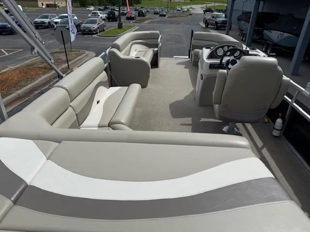 Slide: The Image of 2012 Lowe SS250 pontoon boat interior with beige seating and steering console. - 9