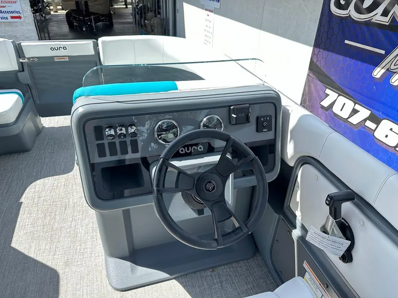 Slide: The Image of 2025 Aura Quad Lounge boat dashboard with steering wheel and controls. - 16