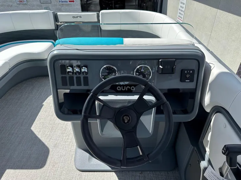 Slide: The Image of 2025 Aura Quad Lounge boat dashboard with steering wheel and control panel. - 17