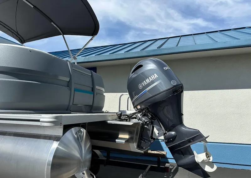 Slide: The Image of 2025 Aura Quad Lounge pontoon boat with Yamaha outboard motor, docked under blue sky. - 5