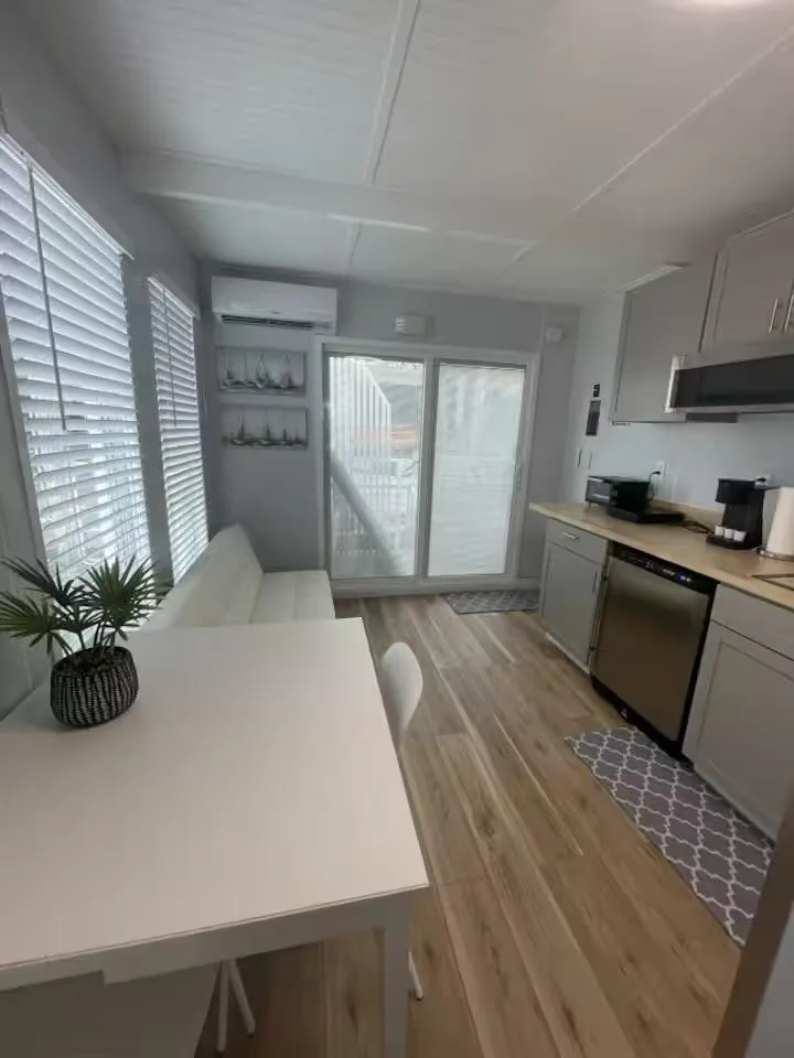 Slide: The Image of Modern kitchen interior with light wood flooring, white table, and stainless steel appliances, 2023 Modern Struktures MS 360. - 7