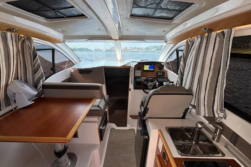 Slide: The Image of 2022 Cutwater C-248 Coupe interior with helm, kitchenette, and seating area. - 25