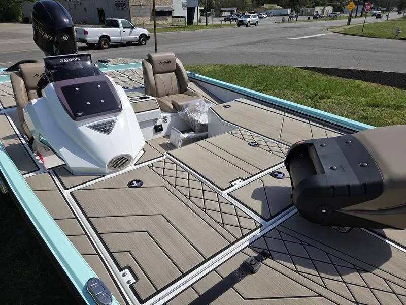 Slide: The Image of 2025 Avid 18 Vertex boat with modern deck design and seating, parked outdoors. - 11