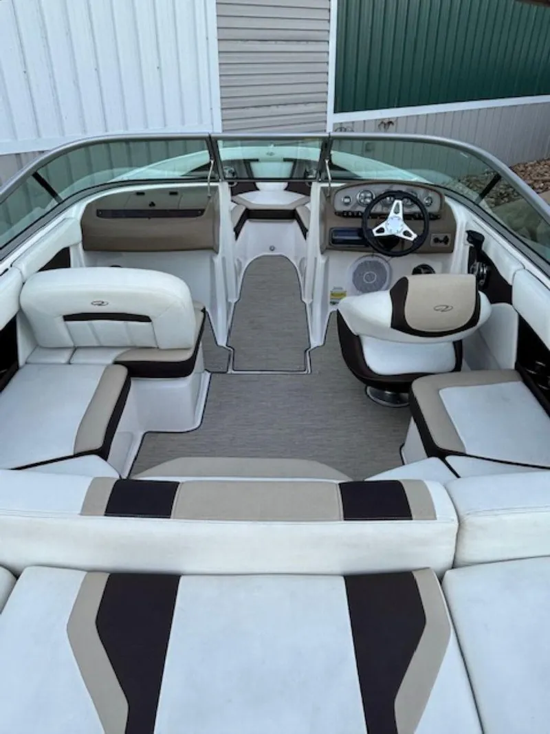 Slide: The Image of 2015 Regal 2000 ES boat interior with white and beige seating, modern dashboard, and steering wheel. - 12