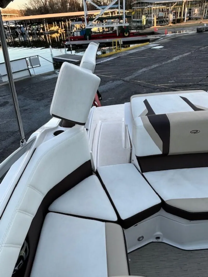 Slide: The Image of 2015 Regal 2000 ES boat interior with white and brown seating at a marina. - 16