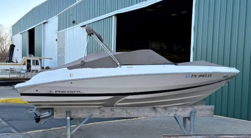 Slide: The Image of 2015 Regal 2000 ES boat on stand near large warehouse. - 26