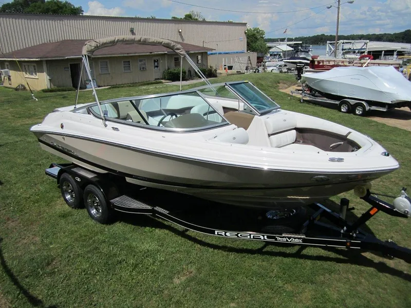 Slide: The Image of 2015 Regal 2000 ES boat on trailer, parked on grass near marina. - 31