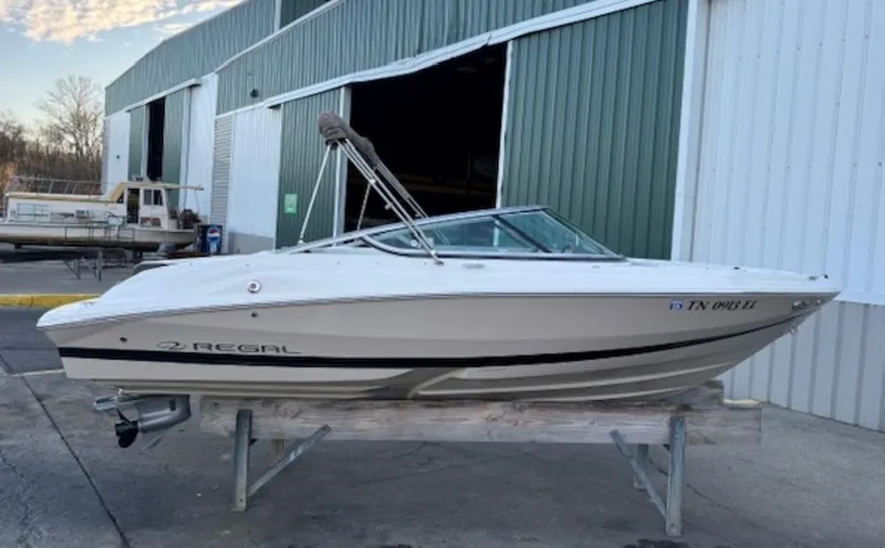 Slide: The Image of 2015 Regal 2000 ES boat on a stand outside a green and white building. - 4