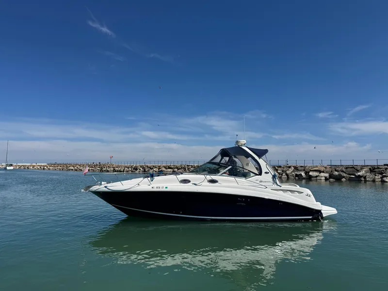 Slide: The Image of 2004 Sea Ray 320 Sundancer boat on calm water under clear blue sky. - 0