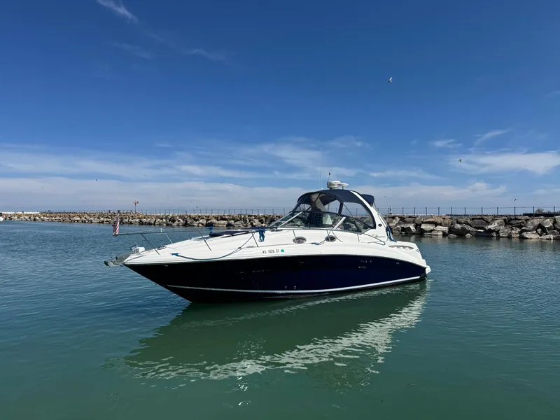 Slide: The Image of 2004 Sea Ray 320 Sundancer boat on calm water under clear blue sky. - 3