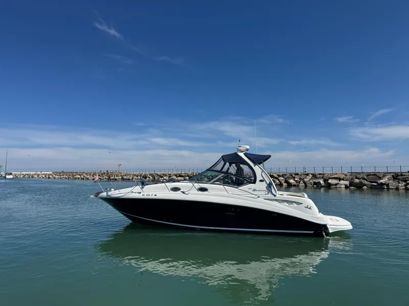 Slide: The Image of 2004 Sea Ray 320 Sundancer boat on calm water under clear blue sky. - 5