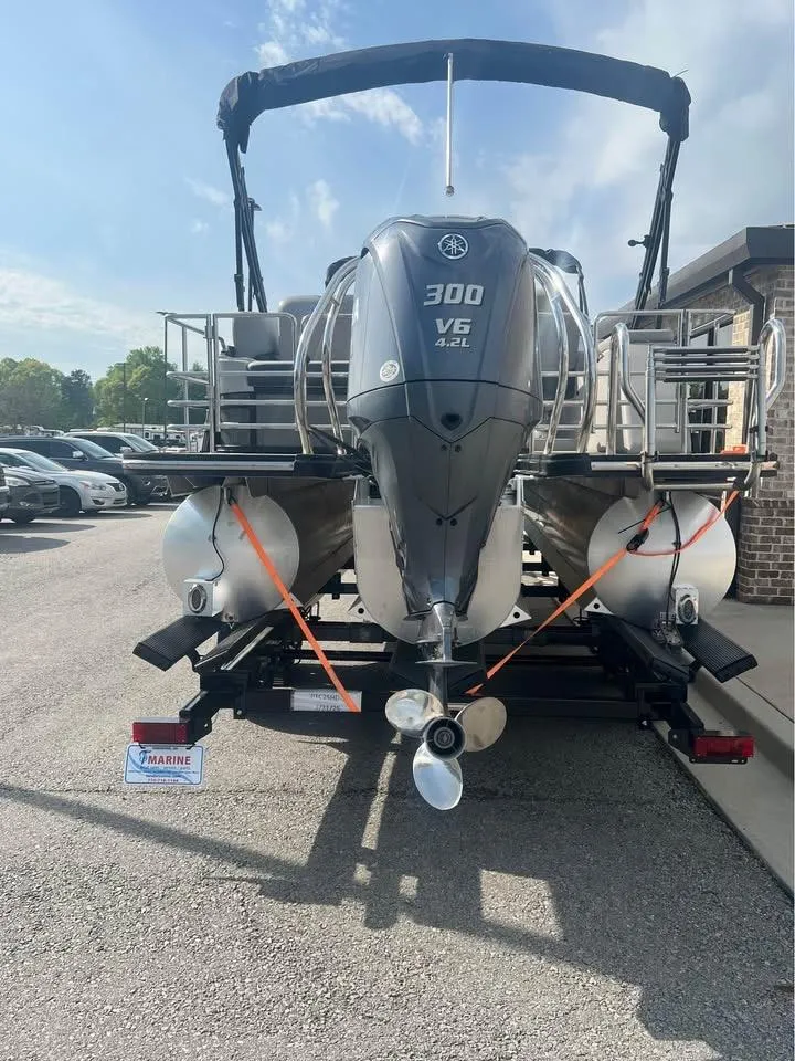 Slide: The Image of 2023 Starcraft SLS 3 Q DH pontoon boat with 300 V6 engine, parked on a trailer. - 4