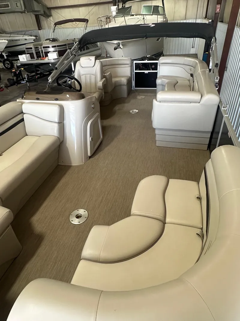 Slide: The Image of 2018 Bennington 21 SSRCX Premium pontoon boat interior with beige seating and helm. - 4