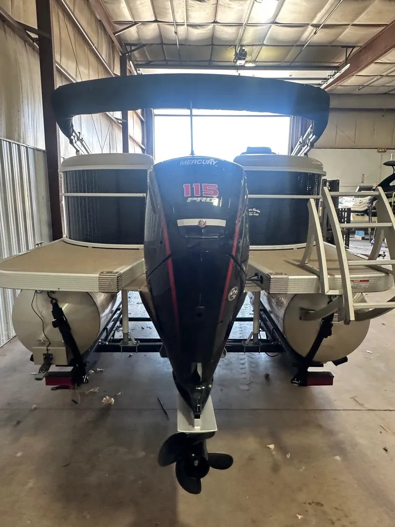 Slide: The Image of 2018 Bennington 21 SSRCX Premium pontoon boat with Mercury 115 Pro motor in a warehouse. - 6