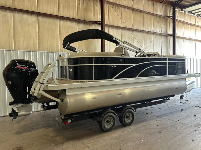 Slide: The Image of 2018 Bennington 21 SSRCX pontoon boat on trailer in warehouse setting. - 7