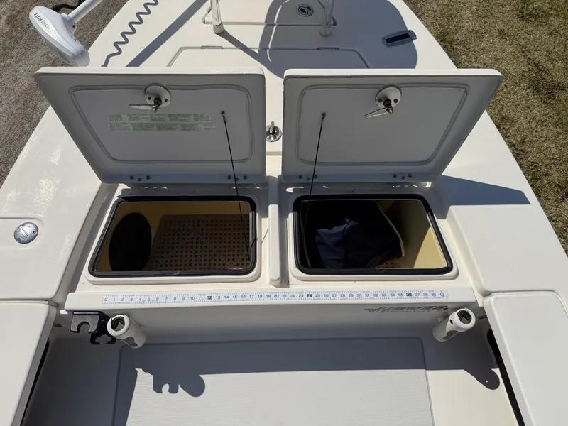 Slide: The Image of 2009 Hewes 18 Redfisher boat storage compartments open, showing interior space and accessories. - 14