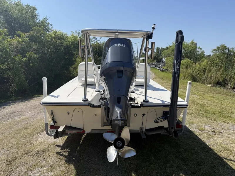 Slide: The Image of 2009 Hewes 18 Redfisher boat with outboard motor, parked on grass. - 17