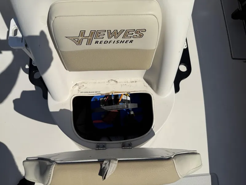 Slide: The Image of 2009 Hewes 18 Redfisher boat seat with storage compartment open. - 25