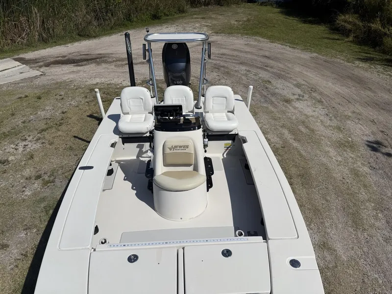 Slide: The Image of 2009 Hewes 18 Redfisher boat with white seating, parked on grassy terrain. - 9