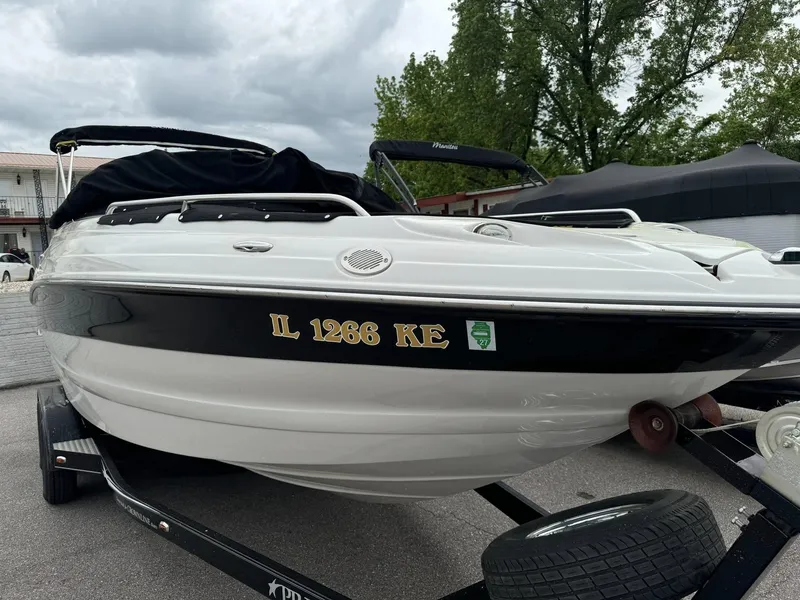 Slide: The Image of 2008 Crownline Bowrider 240 LS on trailer, white and black, parked outdoors. - 15