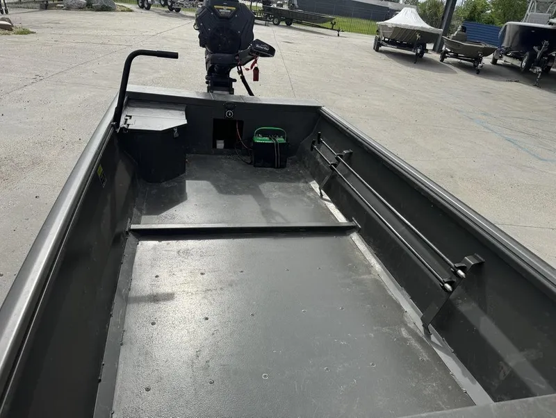 Slide: The Image of 2025 Gator Tail 1748 boat interior with motor, parked on concrete lot. - 12