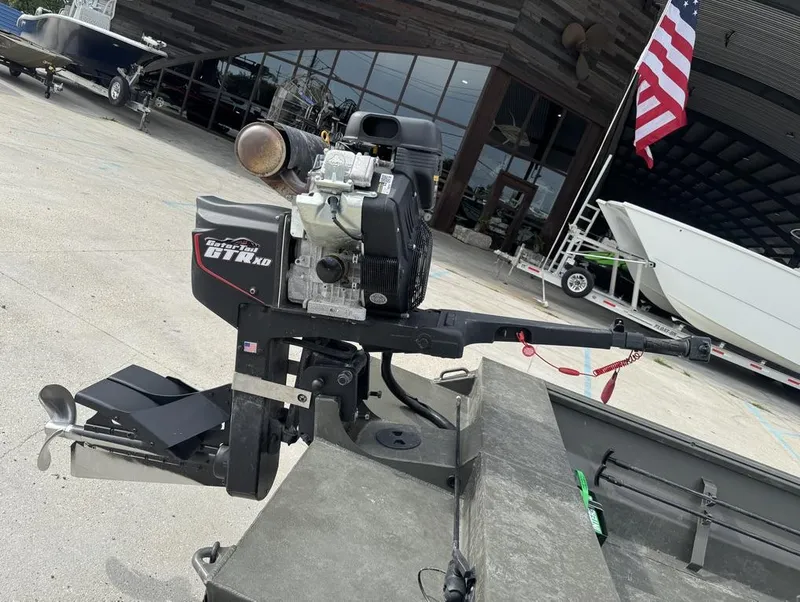 Slide: The Image of 2025 Gator Tail 1748 boat motor, outdoor setting, American flag in background. - 15