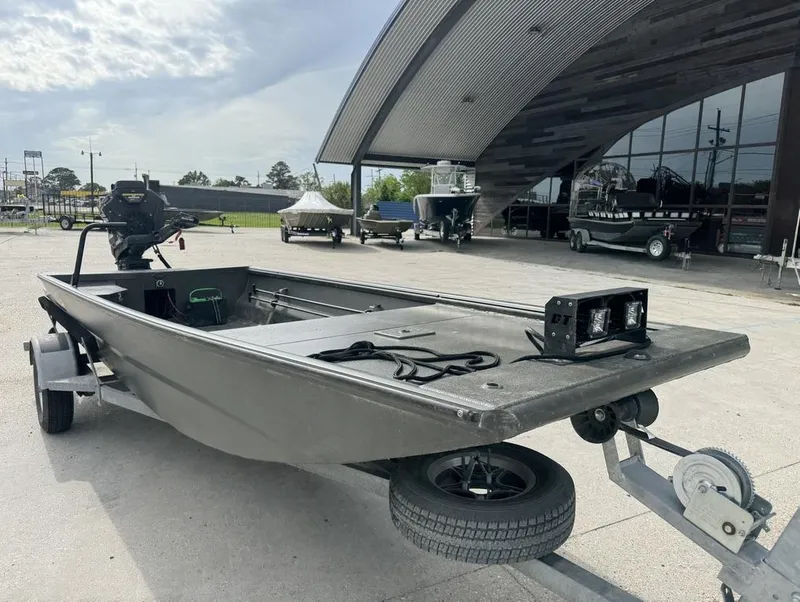 Slide: The Image of 2025 Gator Tail 1748 boat on trailer, parked outside a modern building. - 9