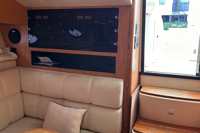 Slide: The Image of Interior of 1998 Tiara Yachts 3500 Open, featuring beige seating and control panel. - 10